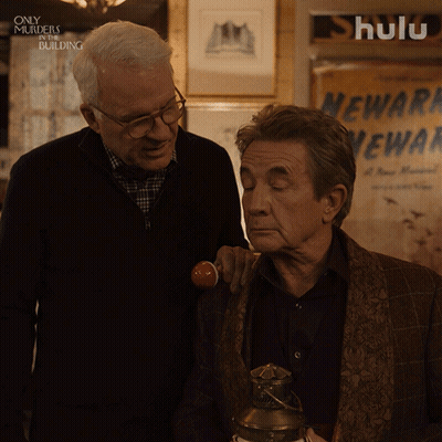 Two Men In Front Of Hulu Sign GIF
