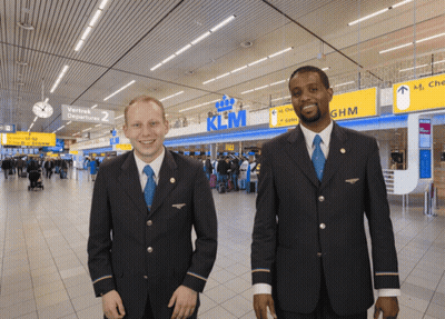 Two Men In Front Of KLM Sign GIF