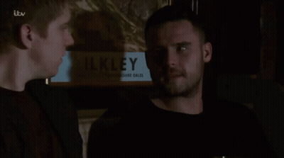 Two Men In Front Of Painting Saying Ilkley GIF