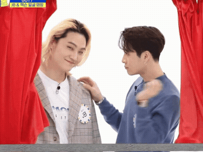 Two Men In Front Of Red Curtain One With JB Name Tag GIF