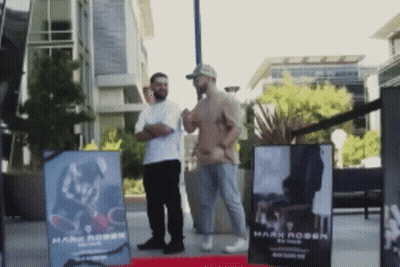 Two Men In Front Of Sign Saying Mark Robin GIF