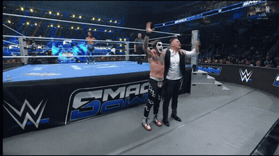 Two Men In Front Of Smackdown Wrestling Ring GIF