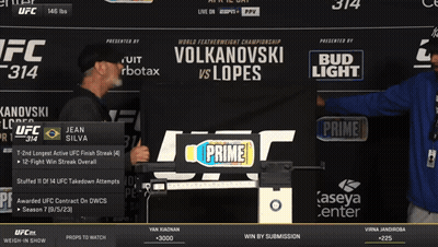 Two Men In Front Of UFC 314 Sign GIF