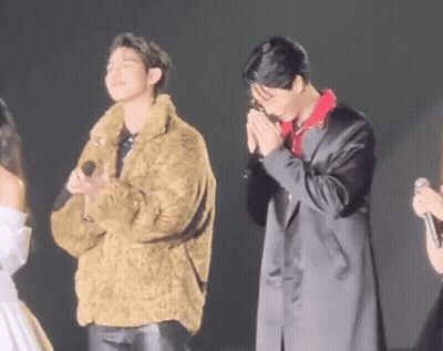 Two Men In Fur And Black Coats On Stage GIF