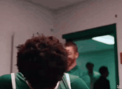 Two Men In Green Shirts Standing Together GIF