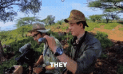 Two Men In Hats And Sunglasses Standing In Field GIF