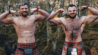 Two Men In Kilts Flex Their Muscles In Front Of Trees With The Words Secret Body Behind Them GIF