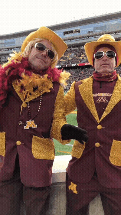 Two Men In Maroon And Gold Outfits With M GIF