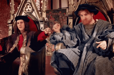 Two Men In Medieval Costumes On A Throne One With Beard GIF