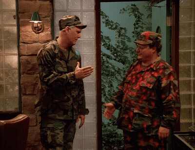Two Men In Military Uniforms Are Shaking Hands GIF