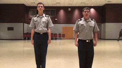 Two Men In Military Uniforms Standing GIF