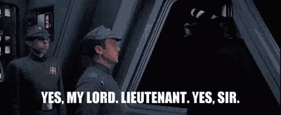 Two Men In Military Uniforms Talking In Dark Room GIF