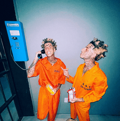 Two Men In Orange Jumpsuits Talking On Phone Saying Change A Call GIF