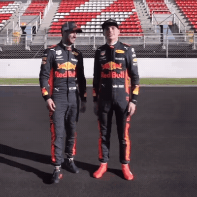 Two Men In Red Bull Racing Suits On Race Track GIF