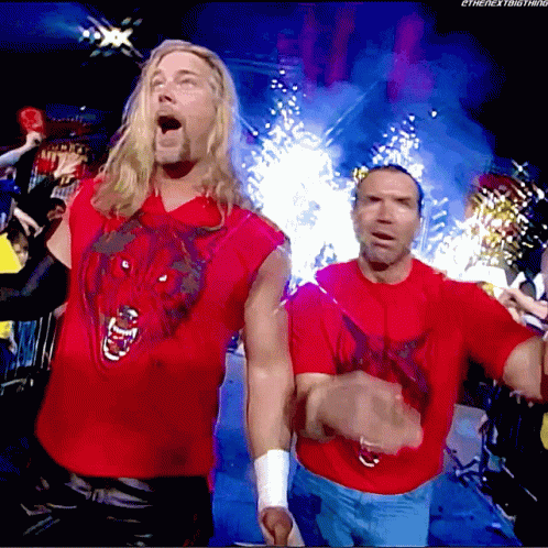 Two Men In Red Shirts Are Standing In Front Of A Crowd With The Words " The Next Big Thing " On The Bottom Right GIF