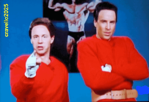 Two Men In Red Sweaters Are Standing Next To Each Other With A Picture Of A Man In Black Underwear Behind Them And The Y GIF