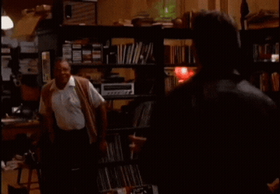 Two Men In Room With Back To The Sixties On Screen GIF