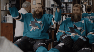 Two Men In Sharks Jerseys Sitting In Chair GIF