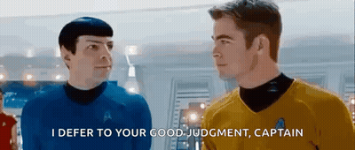 Two Men In Star Trek Uniforms Are Standing Next To Each Other . GIF