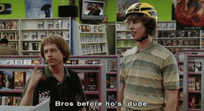 Two Men In Store One Wearing Helmet Talking GIF