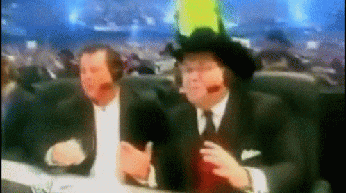 Two Men In Suits And Cowboy Hats At Table With Microphones GIF