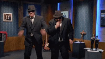 Two Men In Suits And Hats Are Dancing In A Room With A Sign That Says ' A ' On It GIF