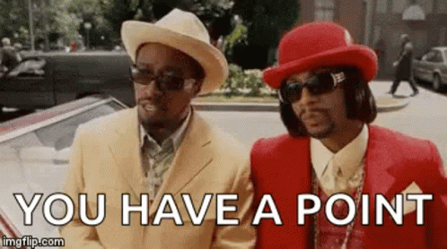Two Men In Suits And Hats Are Standing Next To Each Other On A Street And Talking . GIF