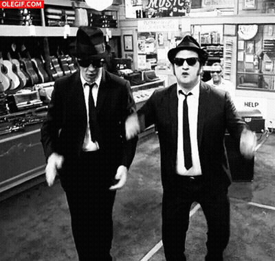 Two Men In Suits And Hats Dancing In Front Of Music Store GIF