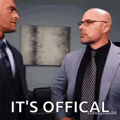 Two Men In Suits And Ties Are Shaking Hands And One Of Them Says It 'S Official GIF