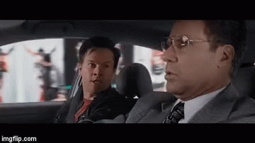 Two Men In Suits And Ties Are Sitting In A Car Talking To Each Other . GIF