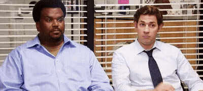 Two Men In Suits And Ties Are Sitting Next To Each Other In Front Of A Window With Blinds . GIF