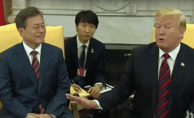 Two Men In Suits And Ties Are Sitting Next To Each Other Talking . GIF