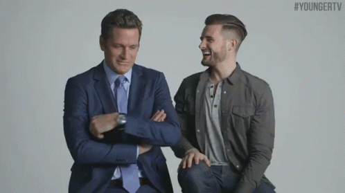 Two Men In Suits And Ties Are Sitting Next To Each Other With Their Arms Crossed .. GIF