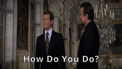 Two Men In Suits And Ties Are Standing In A Room With The Words How Do You Do Below Them GIF