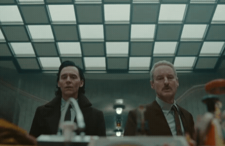 Two Men In Suits And Ties Are Standing Next To Each Other GIF