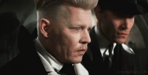 Two Men In Suits And Ties Are Standing Next To Each Other And Looking At Something . GIF