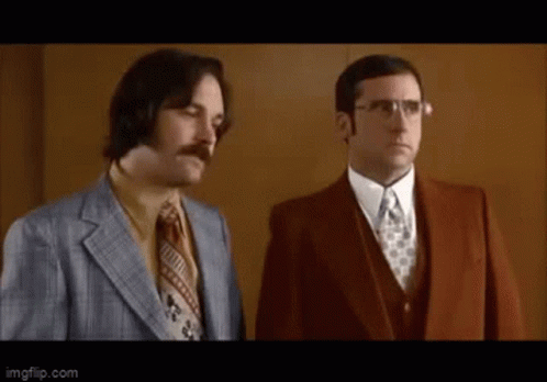 Two Men In Suits And Ties Are Standing Next To Each Other And Looking At Something . GIF