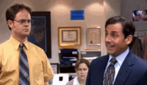 Two Men In Suits And Ties Are Standing Next To Each Other In A Room . GIF