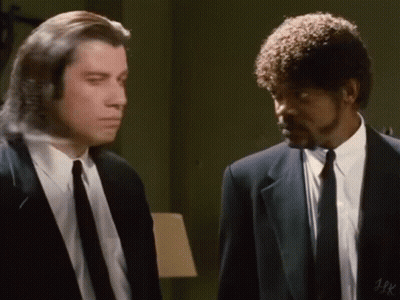 Two Men In Suits And Ties Are Standing Next To Each Other In A Room And Talking . GIF