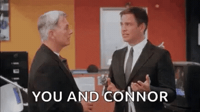 Two Men In Suits And Ties Are Standing Next To Each Other In An Office And Shaking Hands . GIF