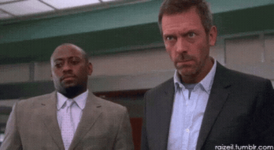Two Men In Suits And Ties Are Standing Next To Each Other Looking At Something GIF