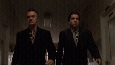 Two Men In Suits And Ties Are Walking Down A Hallway .. GIF