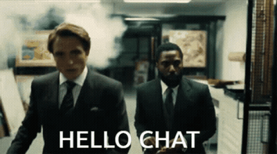 Two Men In Suits And Ties Are Walking In A Hallway With The Words Hello Chat On The Bottom GIF
