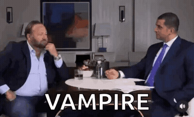 Two Men In Suits And Ties At Vampire Table GIF