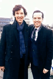 Two Men In Suits And Ties Pose For A Picture Together GIF