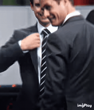 Two Men In Suits And Ties Standing Together GIF
