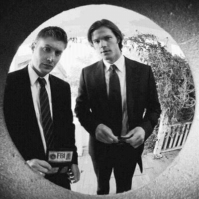 Two Men In Suits And Ties With A Fbi Badge On Their Jacket GIF
