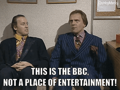 Two Men In Suits Are Sitting Next To Each Other And One Of Them Says This Is The Bbc Not A Place Of Entertainment GIF