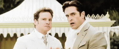 Two Men In Suits Are Standing Next To Each Other In Front Of A White Tent . GIF