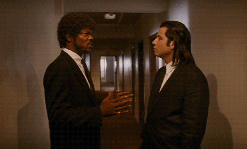 Two Men In Suits Are Talking In A Hallway With The Words It Ain T The Same F * Kin Ballpark Above Them GIF